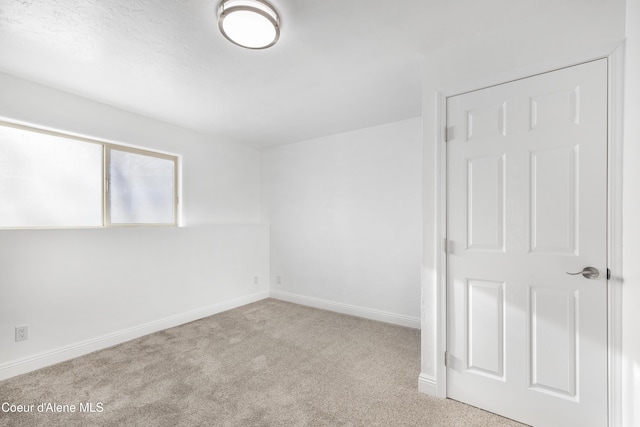 unfurnished room featuring light carpet