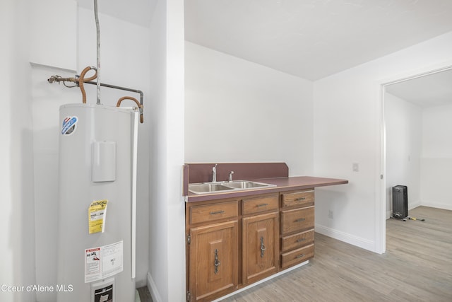 kitchen with light wood-type flooring, electric water heater, and sink