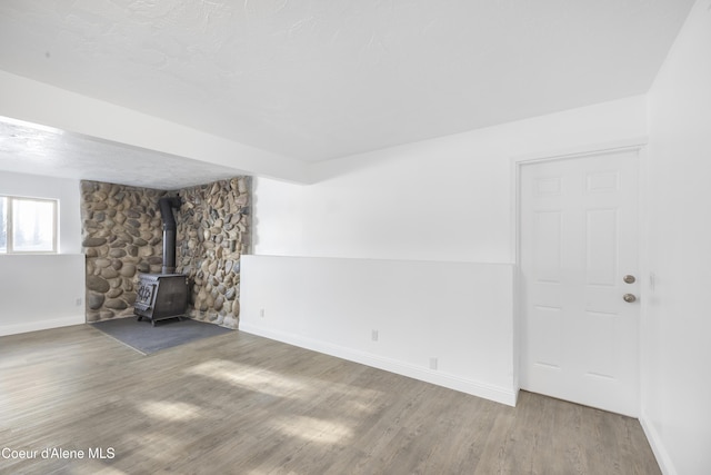 unfurnished living room with a wood stove and hardwood / wood-style floors