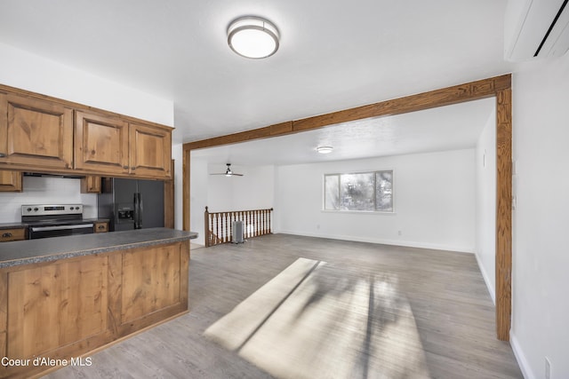 kitchen featuring black refrigerator with ice dispenser, light wood-type flooring, ceiling fan, electric range, and a wall mounted air conditioner