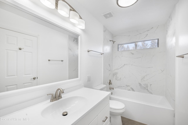 full bathroom featuring toilet, tiled shower / bath combo, and vanity