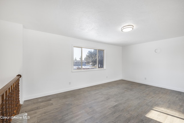 spare room with dark wood-type flooring and a textured ceiling