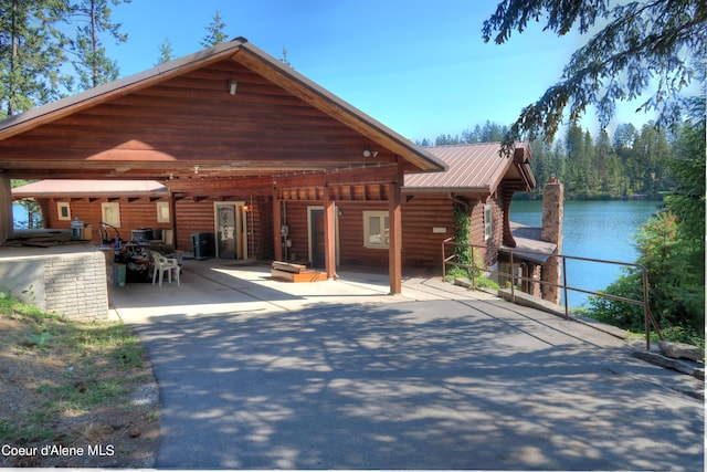 rear view of house with a patio area and a water view