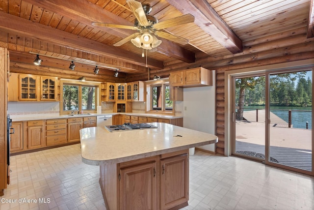 kitchen featuring a water view, a center island, log walls, a wealth of natural light, and beam ceiling