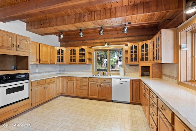 kitchen with sink, beamed ceiling, white appliances, decorative backsplash, and wood ceiling