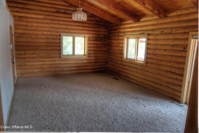 unfurnished room with beam ceiling, wood ceiling, rustic walls, and a wealth of natural light