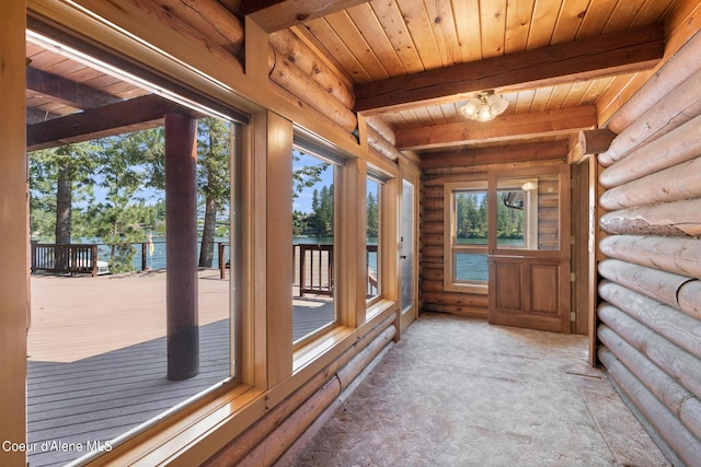 unfurnished sunroom with an inviting chandelier, beam ceiling, wood ceiling, and a water view