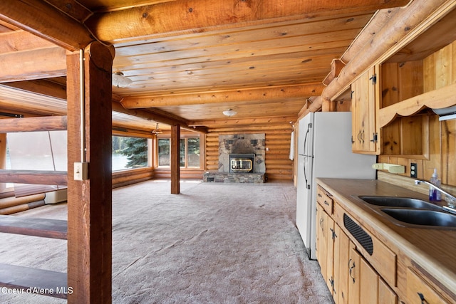 kitchen with rustic walls, wood ceiling, a wood stove, light colored carpet, and sink