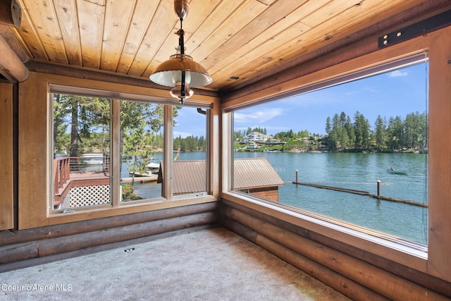 unfurnished sunroom with wooden ceiling, a healthy amount of sunlight, and a water view