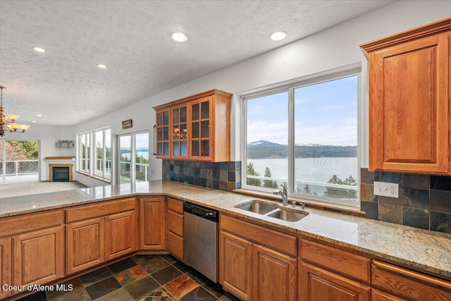 kitchen featuring sink, stainless steel dishwasher, a water view, and tasteful backsplash