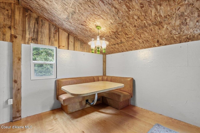 dining space featuring breakfast area, light hardwood / wood-style flooring, and vaulted ceiling