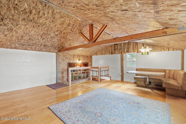 unfurnished living room featuring hardwood / wood-style flooring and vaulted ceiling with beams