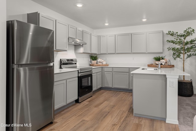 kitchen with kitchen peninsula, gray cabinets, stainless steel appliances, light hardwood / wood-style flooring, and sink