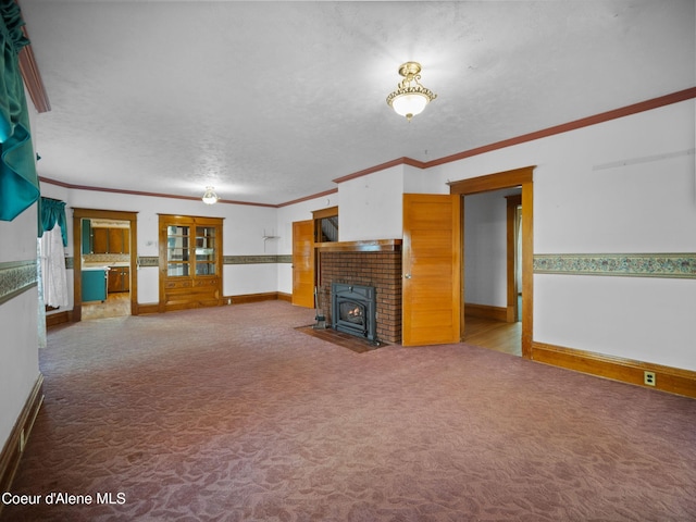 unfurnished living room featuring ornamental molding, carpet floors, a wood stove, and a textured ceiling