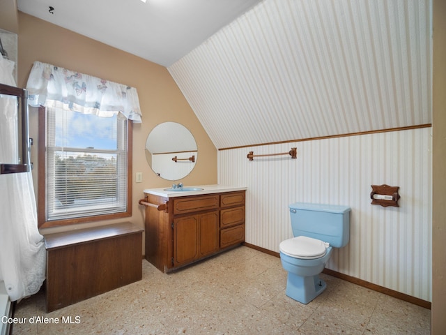 bathroom with vaulted ceiling, vanity, and toilet