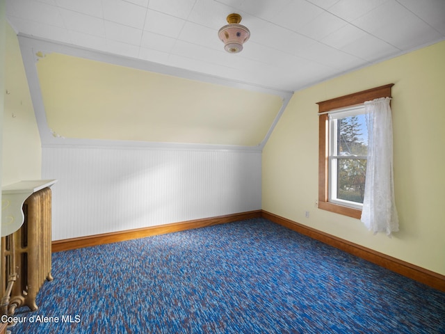 additional living space featuring carpet floors and vaulted ceiling