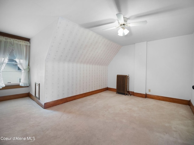 bonus room with ceiling fan, vaulted ceiling, light carpet, and radiator