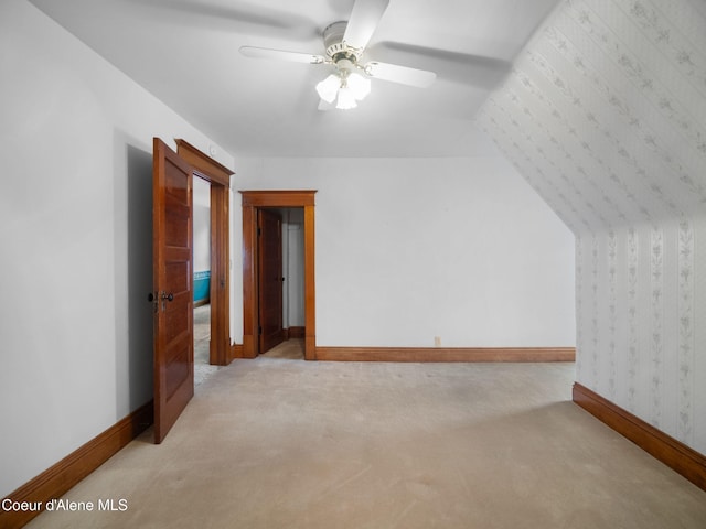 additional living space with light carpet and ceiling fan