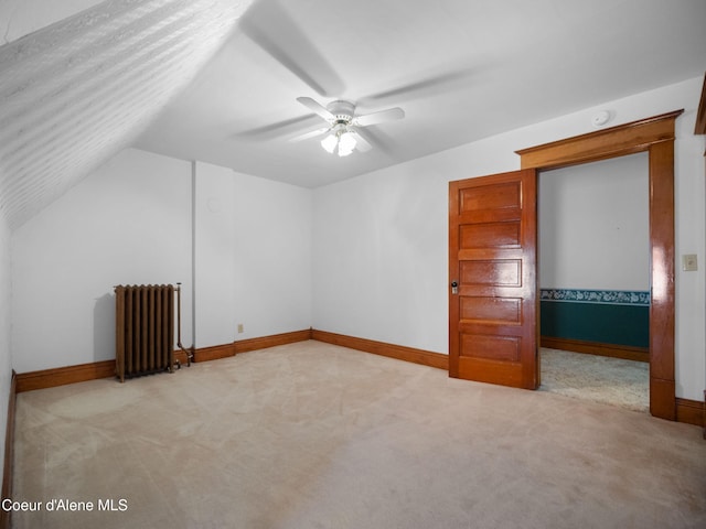 bonus room featuring radiator, ceiling fan, vaulted ceiling, and light colored carpet