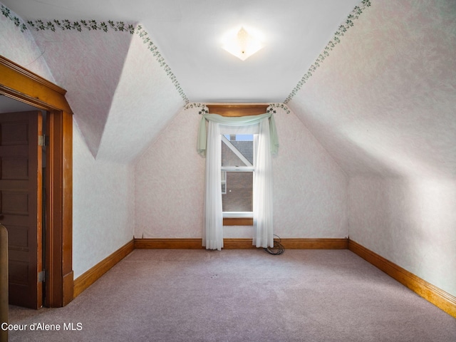 bonus room with lofted ceiling and carpet