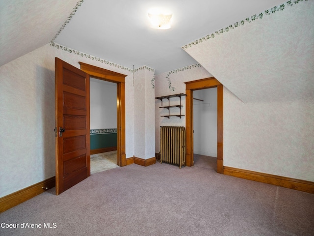 bonus room featuring lofted ceiling, carpet flooring, and radiator