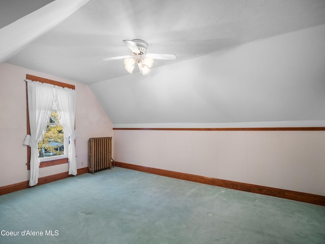 bonus room featuring lofted ceiling, ceiling fan, radiator heating unit, and carpet