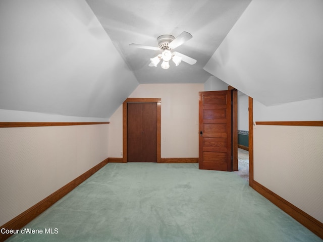 additional living space with lofted ceiling, ceiling fan, and light carpet