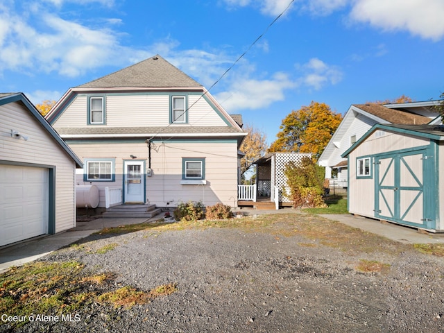 back of house with a storage shed