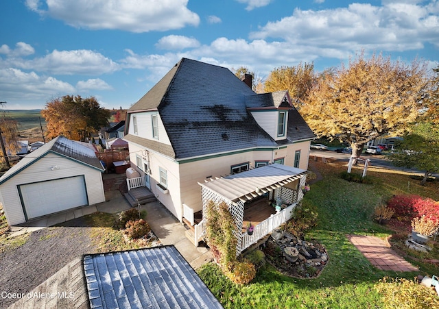 exterior space featuring a garage, covered porch, and an outbuilding