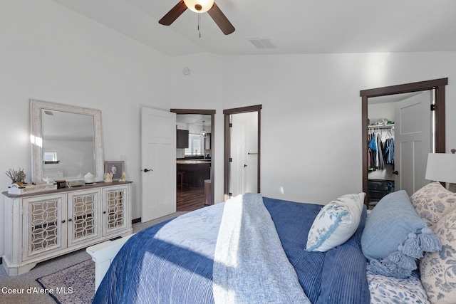 bedroom featuring lofted ceiling, ensuite bath, a spacious closet, a closet, and ceiling fan