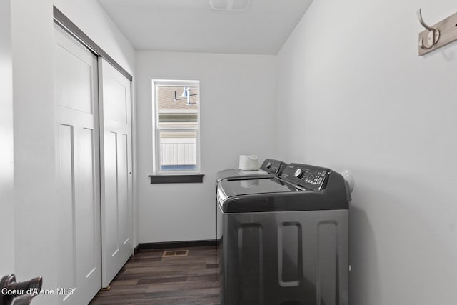 laundry room with dark hardwood / wood-style flooring and washing machine and dryer