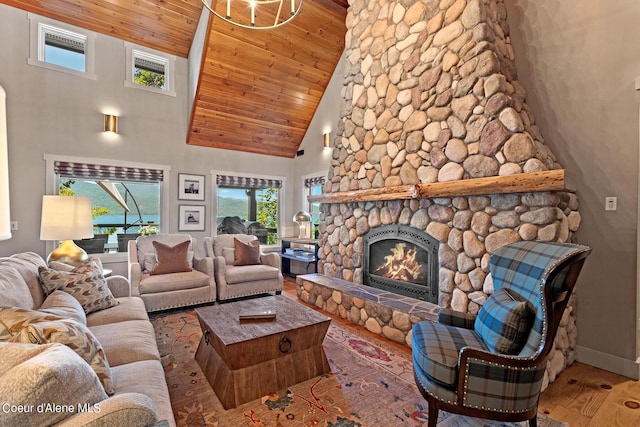 living room featuring high vaulted ceiling, wooden ceiling, hardwood / wood-style flooring, and a stone fireplace