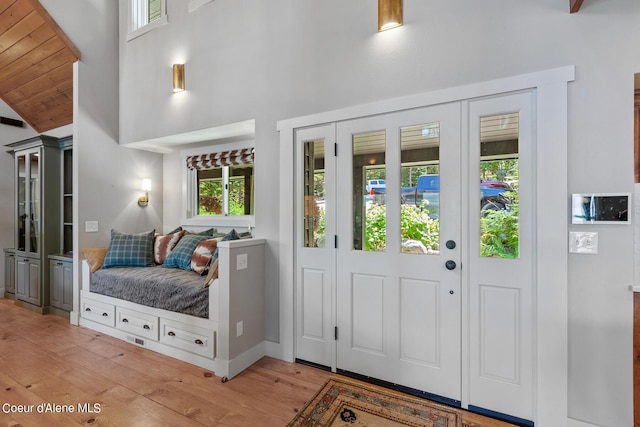 foyer entrance with wood ceiling, light hardwood / wood-style floors, and high vaulted ceiling