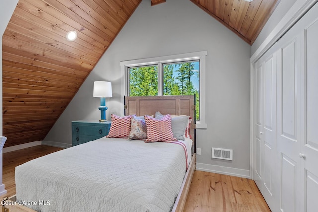 bedroom featuring light hardwood / wood-style flooring, vaulted ceiling, a closet, and wooden ceiling