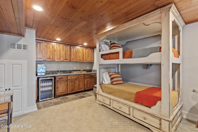 kitchen with sink, light colored carpet, beverage cooler, and wood ceiling