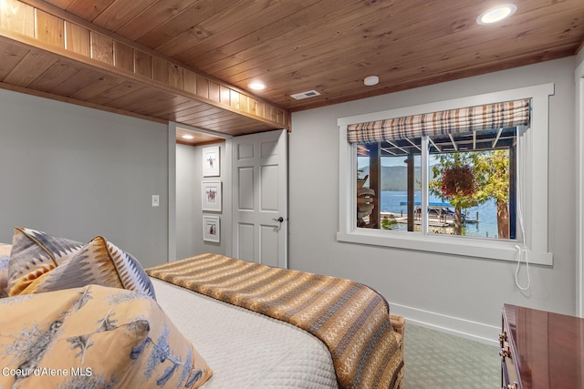 bedroom featuring wood ceiling, a water view, and carpet floors