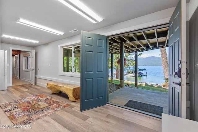 foyer with a water view and wood-type flooring