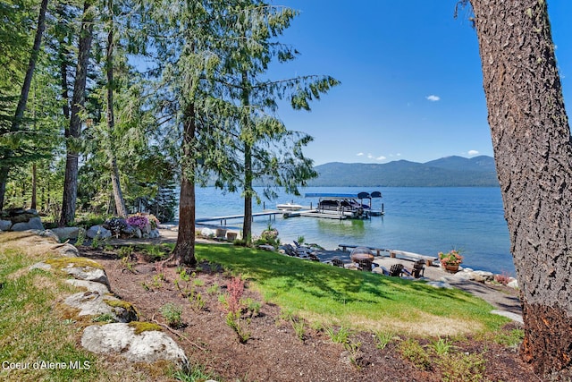 water view with a mountain view, an outdoor fire pit, and a dock