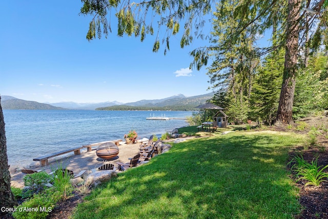 property view of water featuring an outdoor fire pit and a mountain view