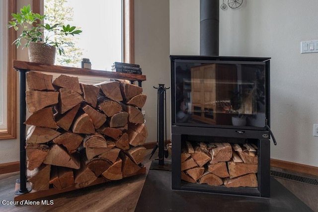 details with a wood stove and hardwood / wood-style floors