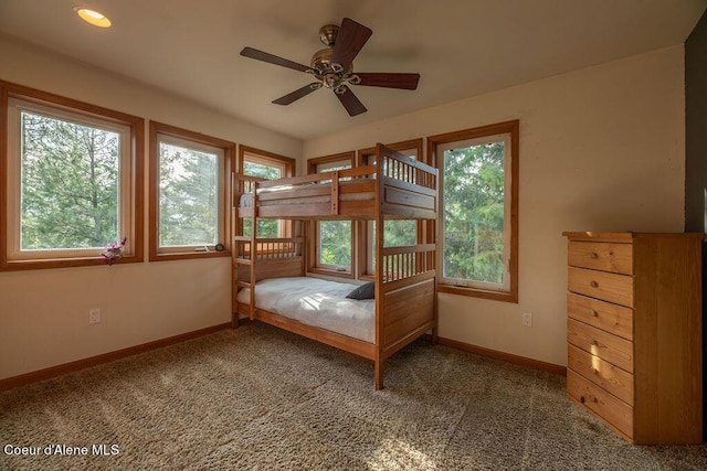 unfurnished bedroom featuring ceiling fan, multiple windows, and carpet flooring