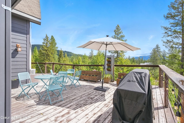 32 Angelina Way, Priest River, ID 83856 - wooden terrace with outdoor dining area, a mountain view, grilling area, and a forest view