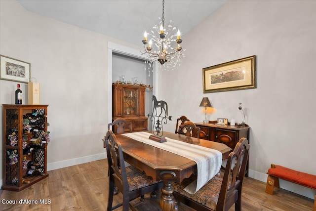 dining room with an inviting chandelier, baseboards, and wood finished floors