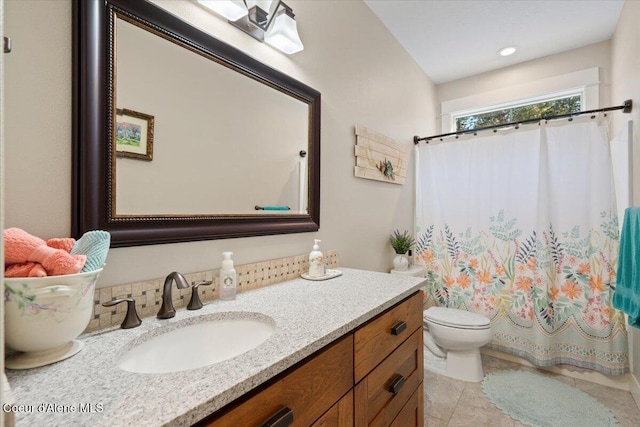 bathroom with curtained shower, vanity, and toilet