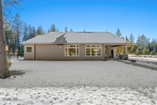 view of snow covered back of property