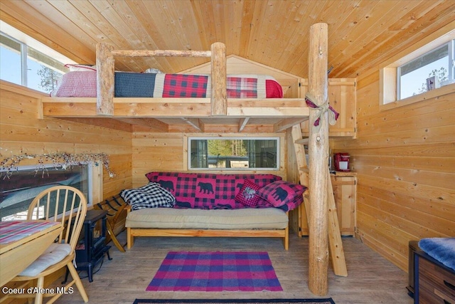 bedroom featuring lofted ceiling, wooden ceiling, wooden walls, and wood finished floors