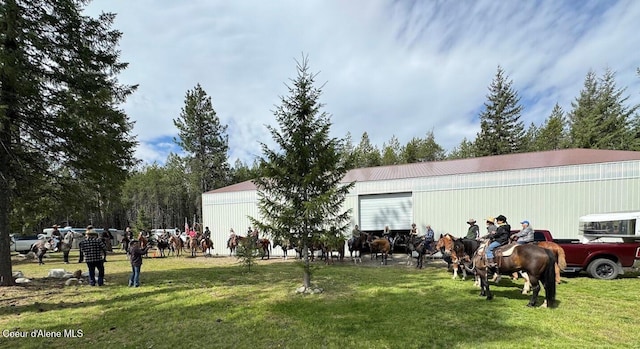 exterior space with a yard, a pole building, and an outbuilding