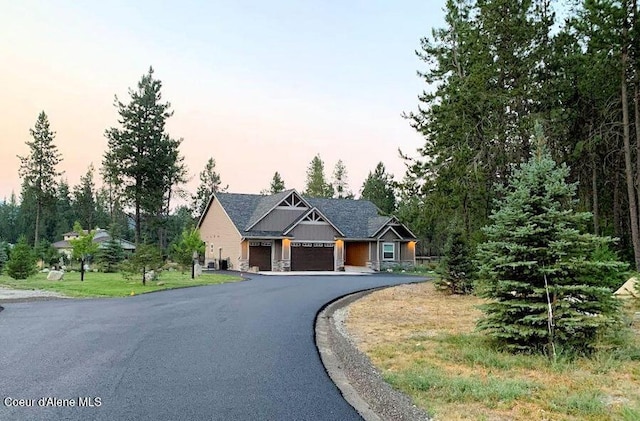 craftsman-style house with aphalt driveway