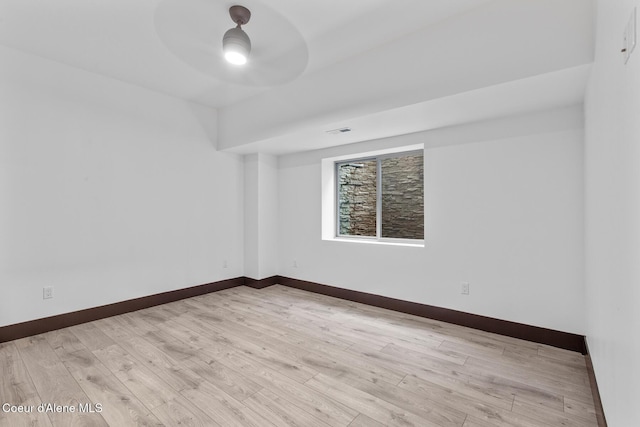 empty room with ceiling fan and light hardwood / wood-style floors