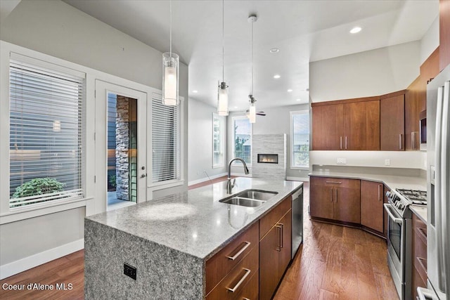 kitchen featuring stainless steel appliances, sink, dark hardwood / wood-style floors, and an island with sink